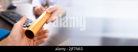 Close-up of a person's Hand passant à Baton de relais d'or Businessman Banque D'Images