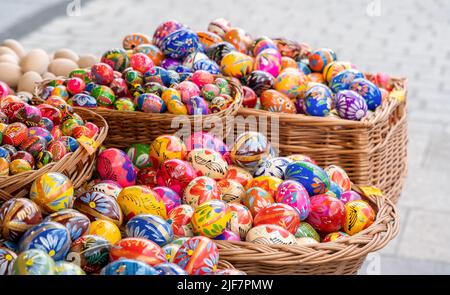 Beaucoup d'oeufs de Pâques faits main colorés dans plusieurs paniers, ensemble de nombreux pisanki polonais artisanaux traditionnels, stand de marché de festival, groupe d'objets Banque D'Images