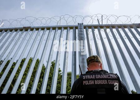 30 juin 2022, Nowodziel, Pologne: Les gardes-frontières patrouillent la barrière physique construite à la frontière entre la Pologne et le Bélarus. La barrière a été construite au cours des deux premiers trimestres de 2022. Le gouvernement polonais a décidé de construire une barrière en acier de 186 kilomètres de long et de 5,5 mètres de haut avec des barbelés à la frontière entre la Pologne et la Biélorussie, qui est aussi la frontière de l'Union européenne et de l'OTAN. La décision a été prise après que des milliers de migrants, principalement originaires de Syrie, d'Iraq et d'Afghanistan, aient tenté de traverser la Pologne depuis le Bélarus. Le gouvernement du Bélarus a été accusé d'orchestrer la migration, avec l'aide fr Banque D'Images