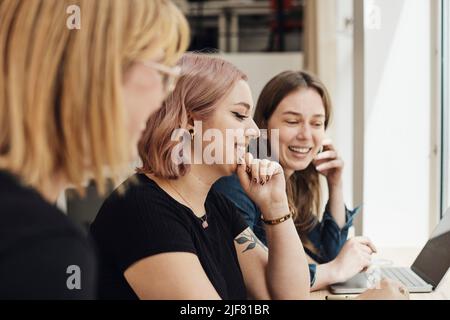 Jeune femme programmeur main sur menton travaillant avec des collègues au bureau de démarrage de technologie Banque D'Images