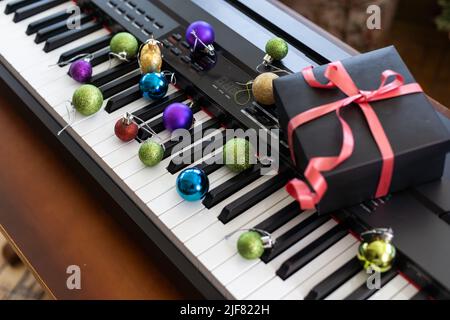 Composition du nouvel an sur un synthétiseur musical. Lumières d'une guirlande.Carte de vœux de joyeux Noël.Bonne année Banque D'Images