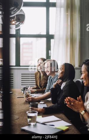 Homme d'affaires et femmes d'affaires heureux discutant ensemble dans la salle de réunion Banque D'Images