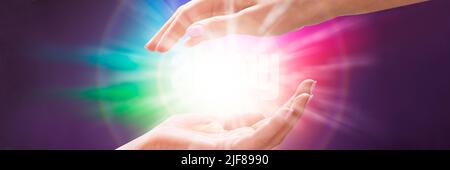 Close-up of a Woman's Hand Holding Light Against Colorful Background Banque D'Images