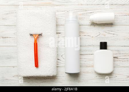 kit homme à raser. machine à raser, serviette, lotion et mousse à raser sur fond coloré. Articles de bain pour hommes vue du dessus. Banque D'Images