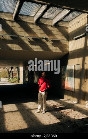 Jeune homme debout sous le passage souterrain Banque D'Images
