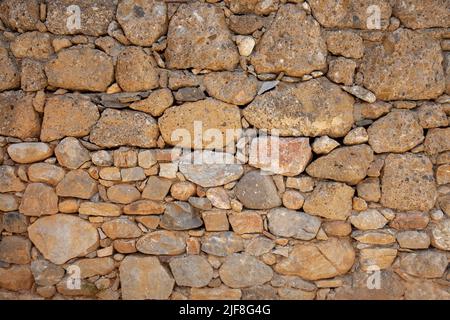 Un vieux mur en pierre fait à l'aide de différents types de pierre. Fond de mur en pierre. Gros plan et vue de face. Banque D'Images