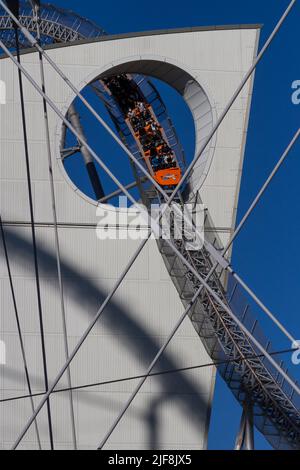 Les montagnes russes Thunder Dolphin traversent un trou dans le bâtiment LaQua du parc d'attractions Tokyo Dome City, Tokyo, Japon. Banque D'Images