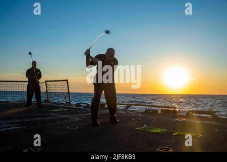 Océan Atlantique. 19th juin 2022. Boatswains Mate 1st classe Febis Soto, à gauche, de New York, Et le technicien du système d'information 2nd classe Kyle Weaver, de Mayport, Floride, jouer au golf sur le pont de vol pendant un événement de la fête des pères sur le moral, le bien-être et les loisirs à bord du destroyer de missiles guidés de la classe Arleigh Burke USS Jason Dunham (DDG 109) dans l'océan Atlantique, au 19 juin 2022. Jason Dunham opère dans l'océan Atlantique à l'appui des opérations navales visant à maintenir la stabilité et la sécurité maritimes afin d'assurer l'accès, de prévenir l'agression et de défendre l'intérêt des États-Unis, des alliés et des partenaires. (CR Banque D'Images