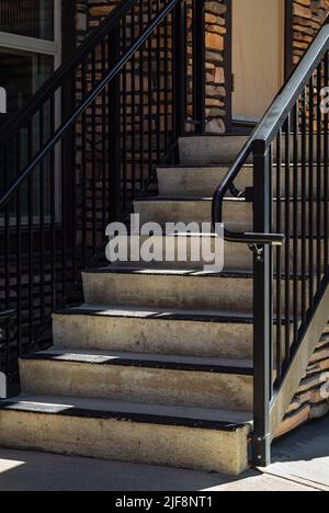 Escalier et lumière du soleil. Entrée du bâtiment. Éléments rambarde d'une maison. Marchepied avec main courante en acier. Personne, photo de rue, photo abstraite Banque D'Images