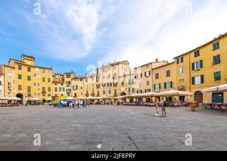 Cafés-terrasses à l'intérieur de la Piazza del Anfiteatro, l'ancien amphithéâtre de la ville toscane fortifiée de Lucques, en Italie. Banque D'Images