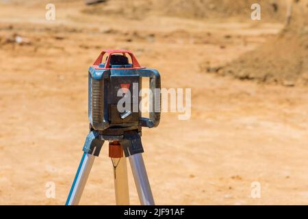 Les entrepreneurs de chantier utilisent une tranchée laser pour un équipement de mesure de construction de fondations en béton Banque D'Images