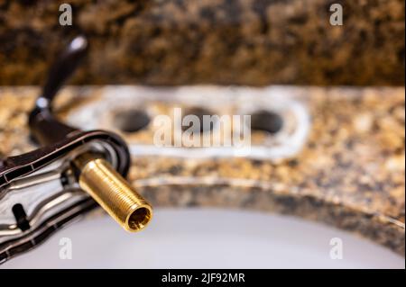 Remplacement d'un robinet d'évier de salle de bains par un nouvel ensemble. Banque D'Images