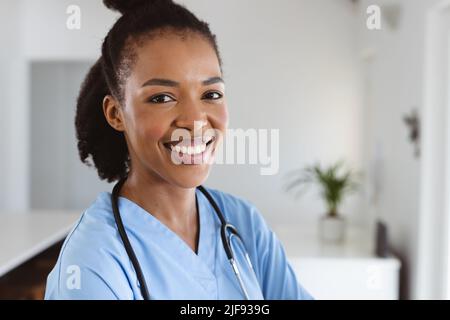 Portrait de jeune femme afro-américaine souriante avec stéthoscope autour du cou à la maison Banque D'Images