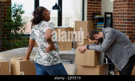 Les partenaires de vie transportant des boîtes de meubles pour déplacer dans le nouveau ménage immobilier, achetant la première maison ensemble. Jour de déménagement comme fiers propriétaires pour la décoration d'appartement. Prise de vue à main levée. Banque D'Images