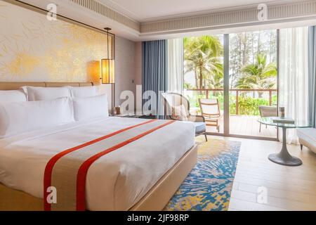 Chambre d'hôtel dans un complexe luxueux et moderne avec vue sur les palmiers tropicaux depuis la fenêtre. Luxueux hôtel de plage pour des vacances d'été. Concept de voyage en Asie Banque D'Images
