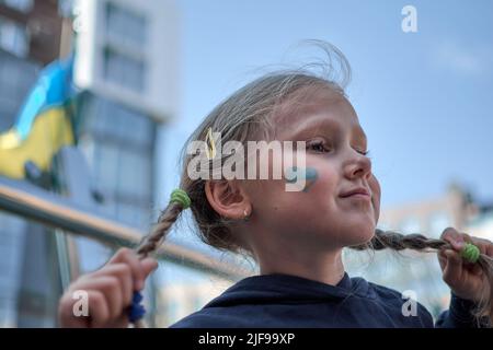 Fille avec drapeau d'Ukraine peint jaune et bleu. Arrêter la guerre et la puissance de l'Ukraine, le patriotisme. Les enfants soutiennent l'Ukraine. Pas de guerre. Priez pour l'Ukraine. Banque D'Images