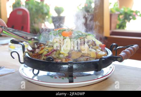 Sach - une grande poêle traditionnelle pour la Bulgarie, dans laquelle des plats sont préparés pour plusieurs personnes, et servis sur la table. Nessebar, Bulgarie Banque D'Images