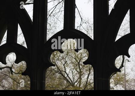 Gros plan sur une silhouette d'une arche à thème floral qui donne sur le jardin. Banque D'Images