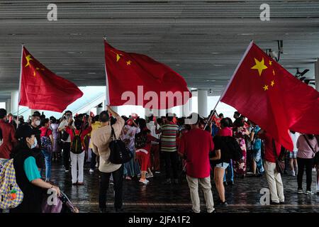 Hong Kong, Chine. 1st juillet 2022. Les supporters chinois tiennent les drapeaux de la République populaire de Chine se rassemblent sur le quai du Star Ferry et célèbrent le transfert de Hong Kong en Chine à l'anniversaire de 25th. Le président chinois Xi Jinping se rend dans la ville pour marquer le 25th anniversaire de la création de la région administrative spéciale de Hong Kong (HKSAR) de la République populaire de Chine. (Image de crédit : © Keith Tsuji/ZUMA Press Wire) Banque D'Images