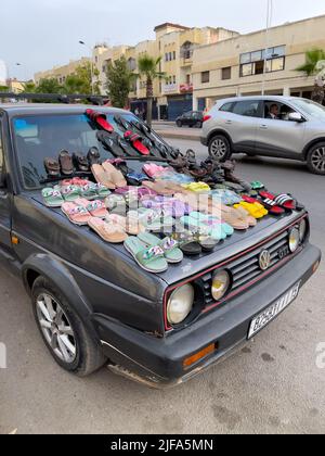 Ensemble de sandales sur le devant d'une vieille voiture dans un marché Banque D'Images