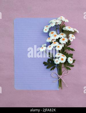 Carte postale minimaliste mignonne avec un bouquet de pâquerettes blanches luxuriantes. Banque D'Images