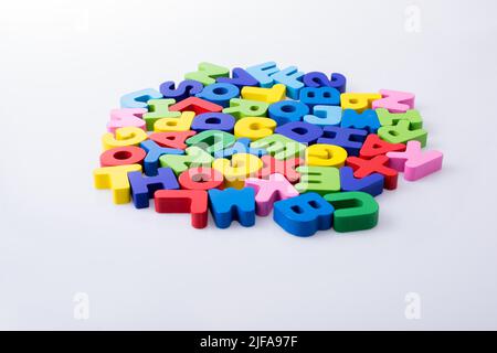 Lettre de l'alphabet blocks colorés répartis au hasard sur fond blanc Banque D'Images