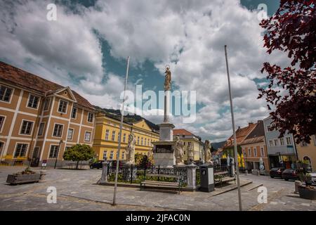 Place avec statues dans le centre de la ville de Murau dans l'état de Steiermark, Autriche. Les bâtiments traditionnels d'europe centrale aux couleurs claires sont sur Banque D'Images