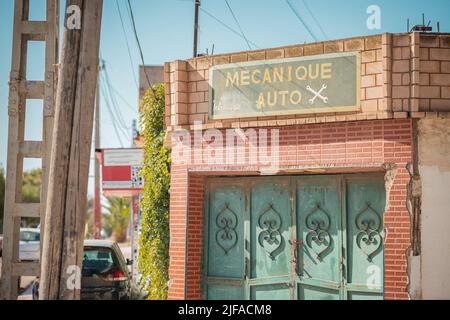 Entrée au garage de réparation ou de service de voiture dans la ville d'Oran, Algérie, Afrique du Nord. Porte métallique fermée devant un garage. Banque D'Images