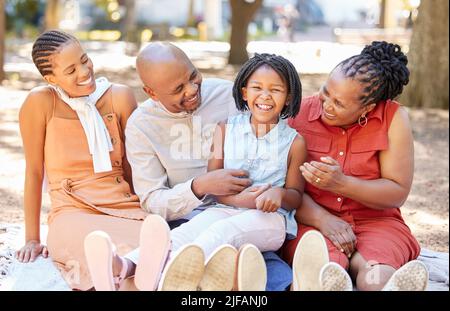 Portrait bonne famille afro-américaine de quatre passer du temps de qualité ensemble dans le parc pendant l'été. Liens entre les grands-parents, la mère et la fille Banque D'Images