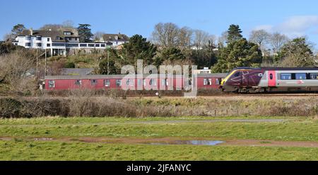 Un train de cross-country passant devant des entraîneurs de camping à Dawlish Warren, South Devon. Banque D'Images