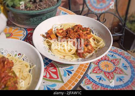 Deux plats de pâtes sur une table en céramique colorée Banque D'Images