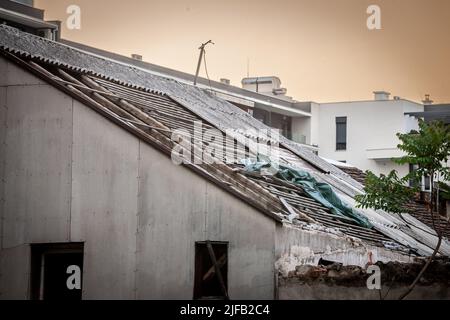 Photo d'une maison de soutènement, décadée, endommagée, avec un toit en amiante, partiellement enlevée. Banque D'Images