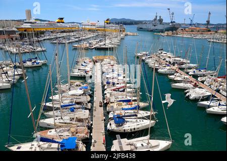 France, Var, Toulon, quai Kronstadtthat donne sur le port civil, en arrière-plan à gauche le port commercial et les ferries à destination de la Corse, en arrière-plan à droite la base navale et le Mistral (L9013) véhicule amphibie hélicoptère de la Marine française en arrière-plan Banque D'Images