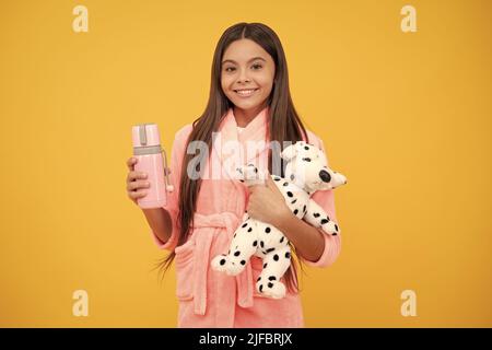 enfant porter une chemise de nuit douce jouer avec le jouet. enfant dans un vêtement de nuit confortable. beauté de la peau. doux rêves. Banque D'Images