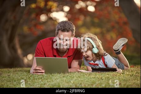 formation en ligne sur ordinateur portable. père et fils utilisent la technologie de communication moderne Banque D'Images