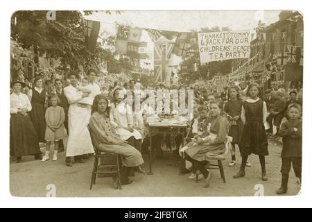 Carte postale originale datant de l'époque WW1 d'un groupe d'enfants assis à des tables à l'extérieur de la rue pour une partie de la paix qui célèbre la fin de la guerre mondiale de 1st - la bannière se lit comme suit : « Merci à Tommy & Jack for Our Childrens Peace Tea », Boston Rd., Walthamstow London, R.-U. daté de 1918 Banque D'Images