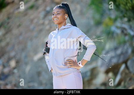 Jeune femme afro-américaine heureuse en randonnée sur une montagne, en faisant une pause pour se reposer. Noir de forme ethnique jeune femme souriante travaillant dans la nature. Athlétique Banque D'Images