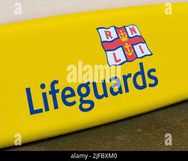 Norfolk, Royaume-Uni - 16 mai 2022 : gros plan du symbole RNLI Lifeguards sur un tableau de sauvetage dans la ville côtière de Sheringham, Norfolk, Royaume-Uni. Banque D'Images