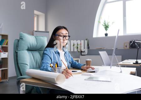 Jeune belle architecte asiatique travaillant sur un projet dans un studio de bureau architectural. Banque D'Images