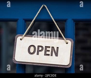 Gros plan d'une affiche OUVERTE sur la porte d'un magasin. Banque D'Images