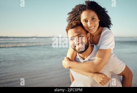 Portrait en gros plan d'un jeune couple de course mixte affectueux debout sur la plage et souriant pendant le coucher du soleil à l'extérieur. Couple hispanique montrant l'amour et Banque D'Images