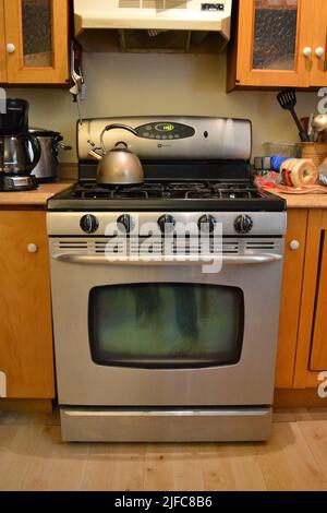 Cuisinière à gaz dans une cuisine ancienne et peu rangée Banque D'Images