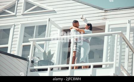 Amoureux jeune couple de course mixte en pyjama partageant un moment romantique tout en dansant sur le balcon de leur nouvelle maison ou pendant les vacances appréciant leur Banque D'Images