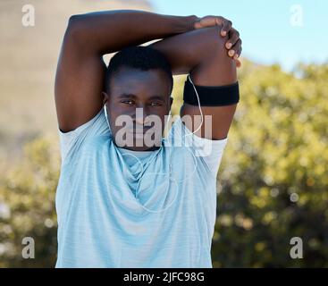 Il faut un jeune homme afro-américain qui étire les bras et les épaules pour se réchauffer avant une course à l'extérieur. Un athlète sérieux et charmant qui s'étire son corps avant Banque D'Images