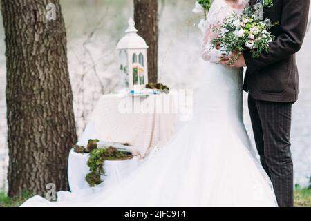 Un couple marié vient de se marier à l'extérieur avec un bouquet Banque D'Images