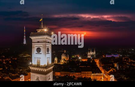 Vue aérienne sur l'hôtel de ville de Lviv la nuit depuis un drone avec la foudre sur le ciel Banque D'Images