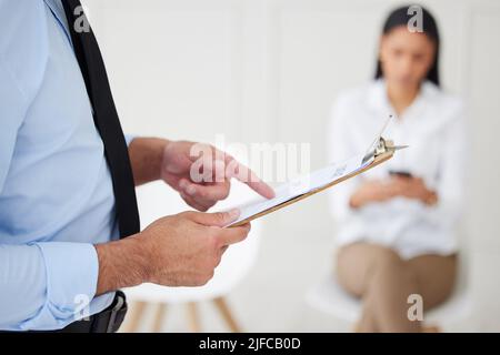 Gros plan d'un gestionnaire d'embauche de race mixte inconnu utilisant le presse-papiers pendant l'entrevue. Homme d'affaires hispanique appelant le candidat pour l'ouverture d'un poste, la vacance, le bureau Banque D'Images