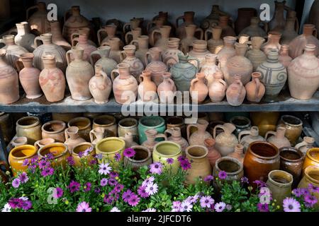 Beaucoup de cruches et vases en argile uniques et colorés faits à la main de formes diverses sur l'étagère dans le marché local Banque D'Images