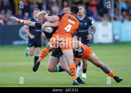 Oliver Wilson de Huddersfield Giants est attaqué par Nathan Massey (à droite) Jake Mamo (à gauche) de Castleford Tigers lors du match de la Super League de Betfred à Castleford, dans la jungle du mend-A-loope. Date de la photo: Vendredi 1 juillet 2022. Banque D'Images