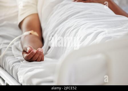 Gros plan d'un patient mâle malade allongé dans le lit d'hôpital avec une goutte de solution saline dans le bras. Gros plan d'un patient mâle malade allongé dans le lit d'hôpital avec une goutte d'eau salée Banque D'Images